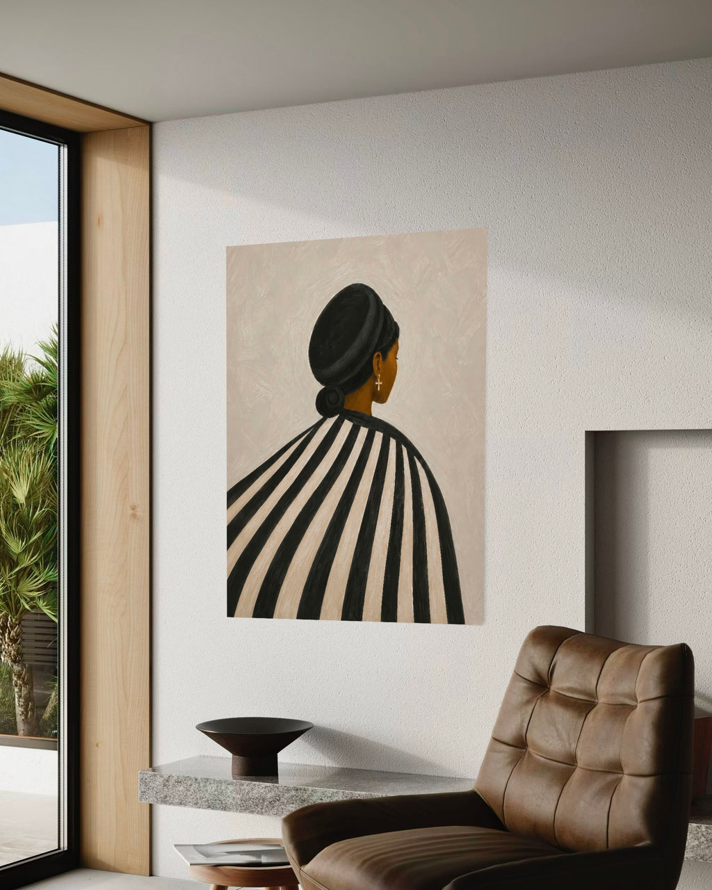 Black woman striped poster displayed beside a brown leather chair in a modern sunlit interior