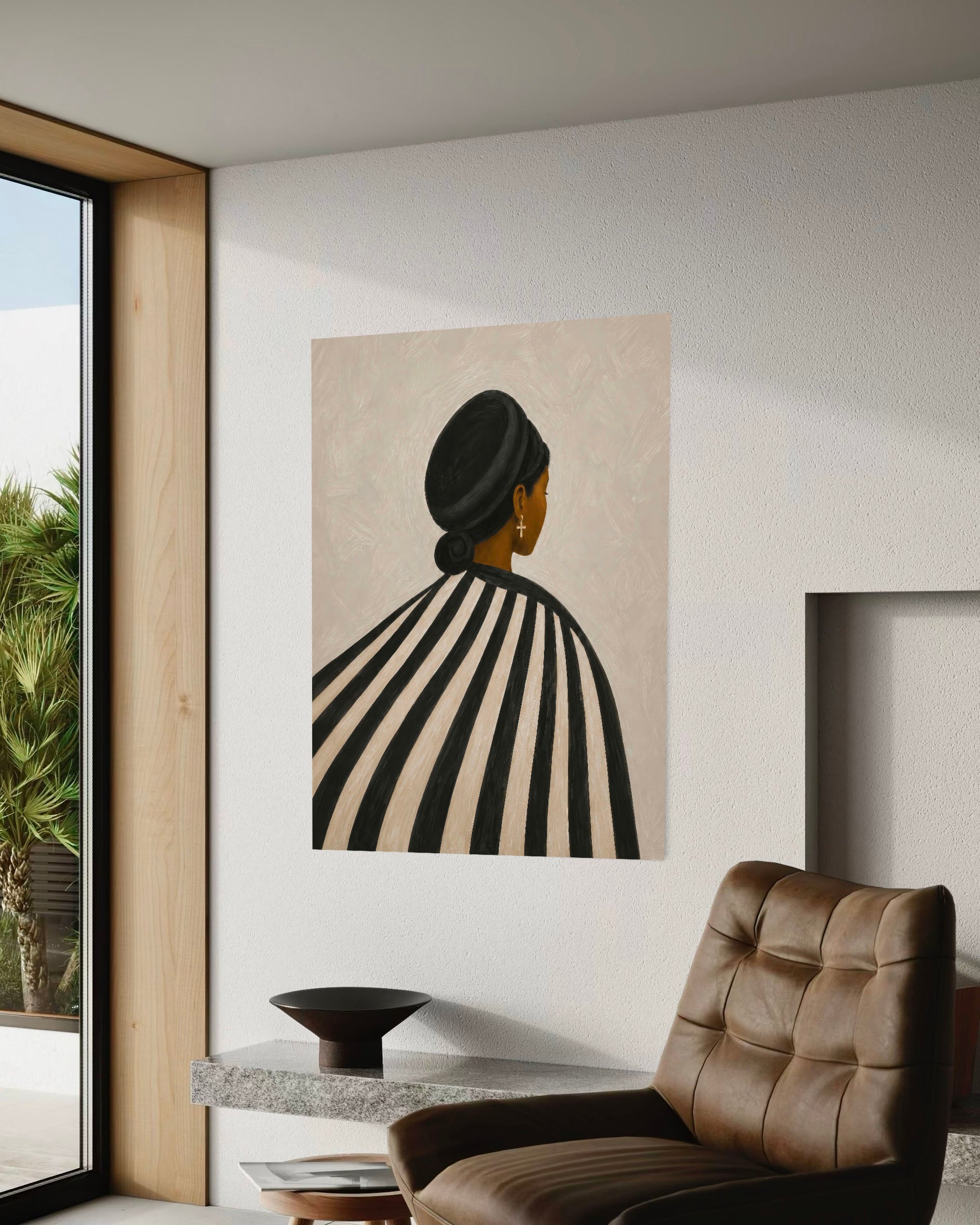 Black woman striped poster displayed beside a brown leather chair in a modern sunlit interior