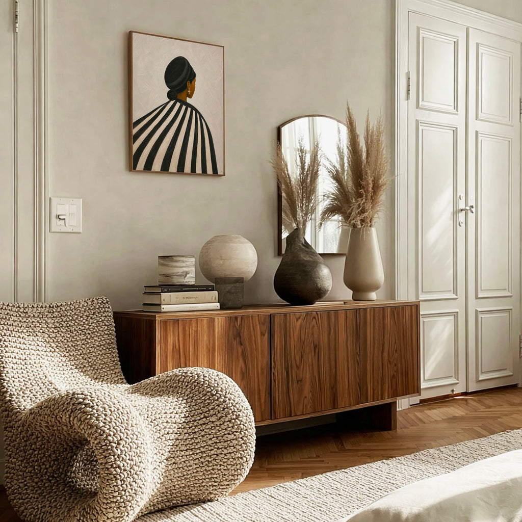 Black woman wall art styled above a wooden sideboard in a beige living room